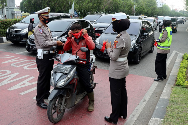 Polisi Ganteng dan Cantik bagi Masker di Simpang Lima