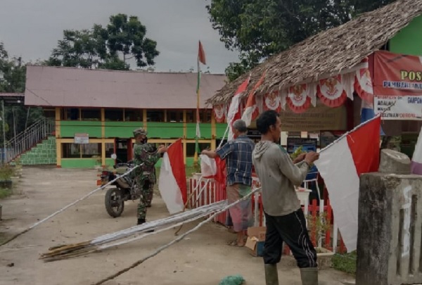 Babinsa dan Warga Pasang Bendera Merah Putih